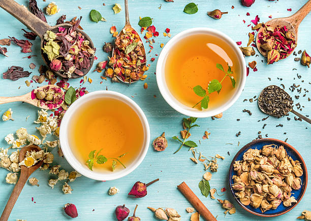 Two cups of healthy herbal tea with mint, cinnamon, dried rose and camomile 